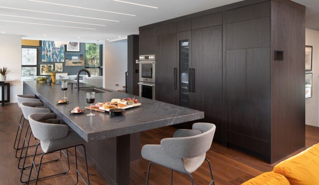 modern kitchen with dark cabinets and a large island with a sink